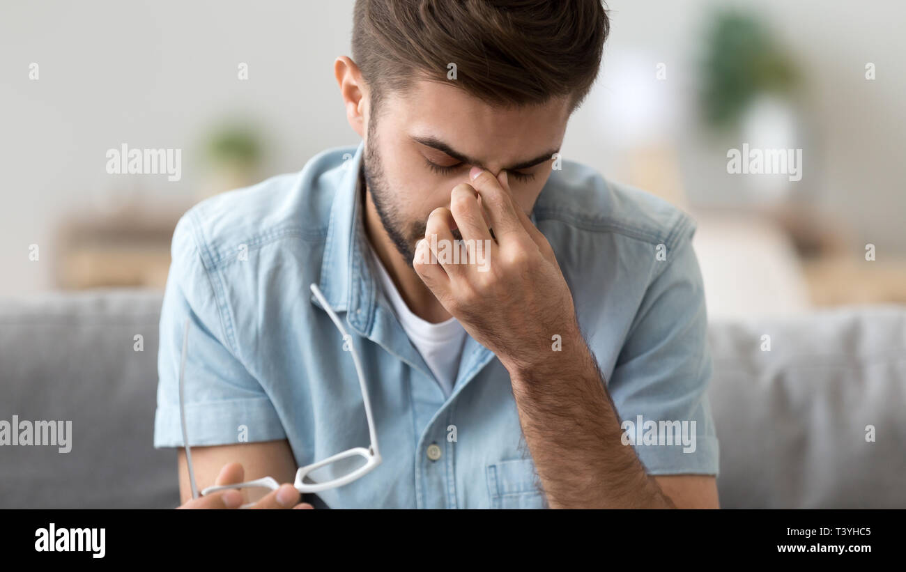 Close up man take off glasses, suffering from dry eyes syndrome Stock