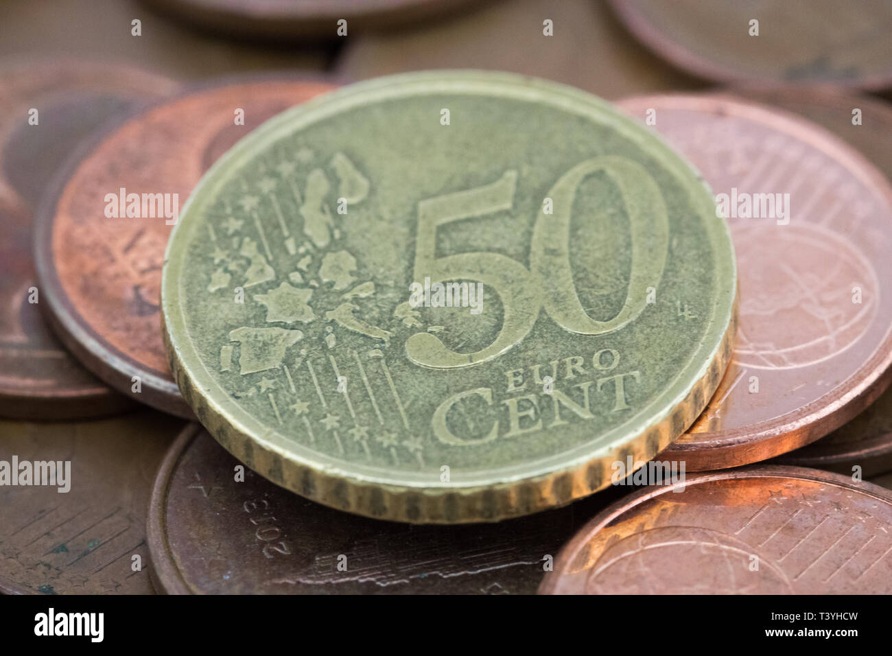 Coin of fifty euro cents on several bronze coins of five euro cents Stock Photo Alamy