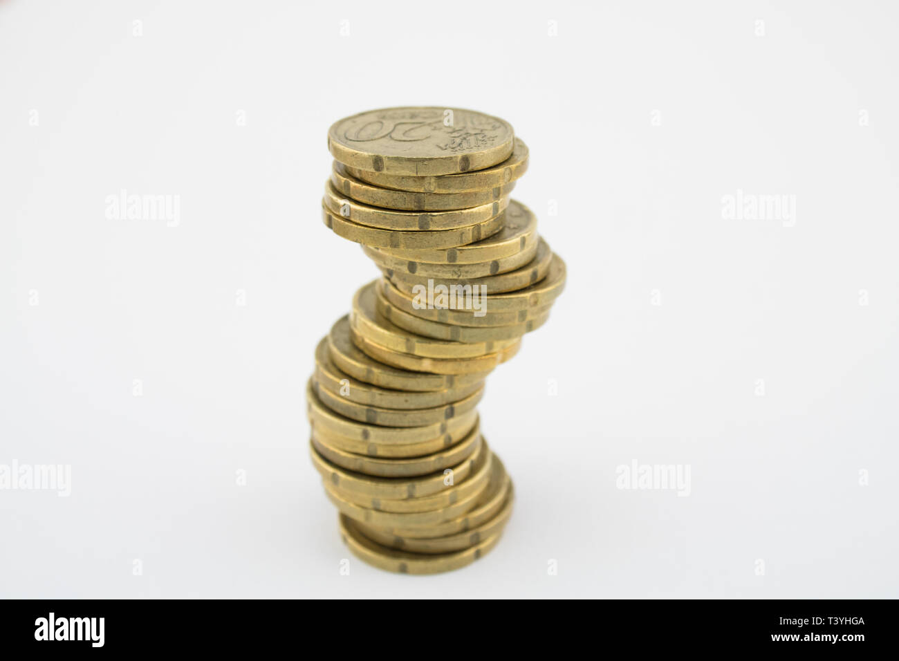 Unstable economy. Stack twenty euro cent coins on white background. Savings of coins. Stock Photo