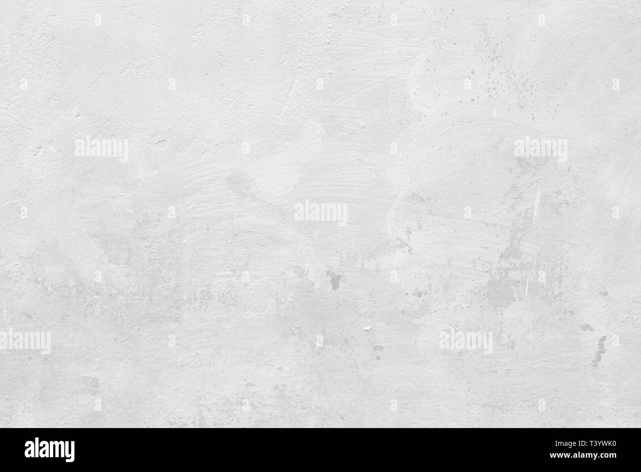 Close-up of a stone or concrete wall painted in white, paint slightly peeled off. Full frame texture background in black and white. Stock Photo