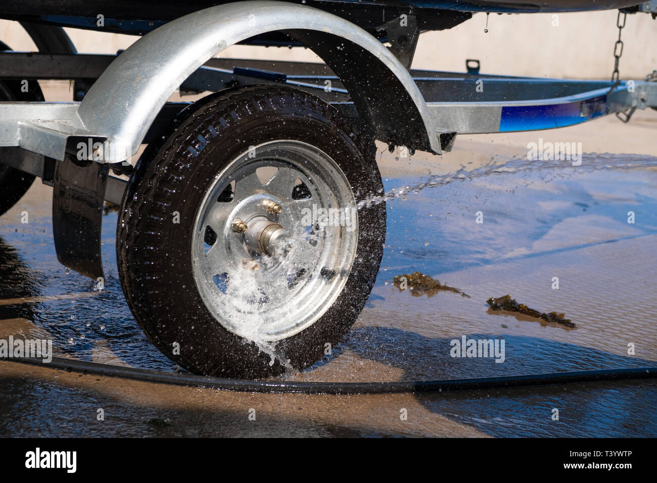 A man washes a rubber hose boat after going to sea. Drops of water scatter  from the boat Stock Photo - Alamy