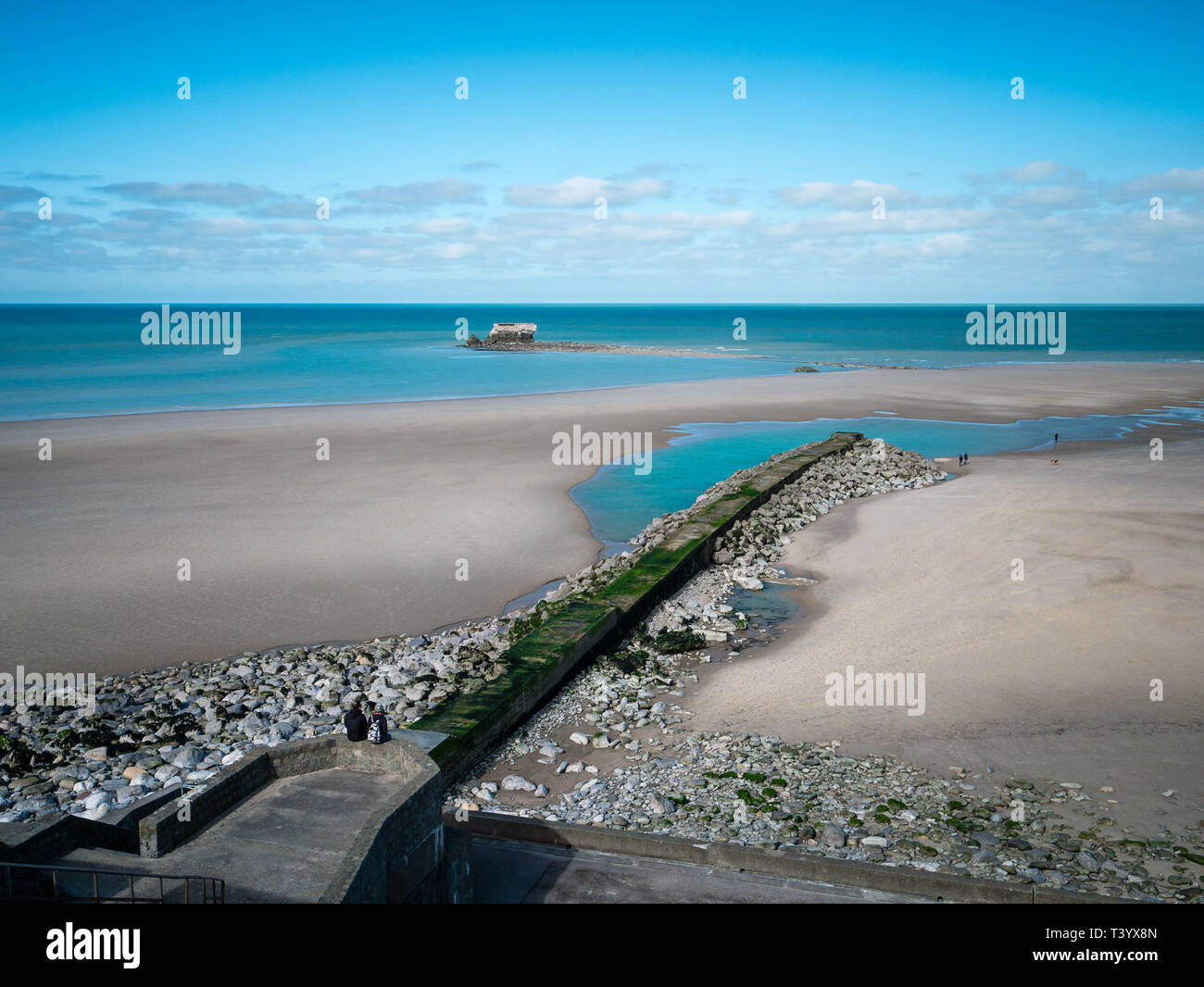 Elevated view of the ancient Fort de l'Heurt surrounded by water on a sandy beach with a mole in the foreground Stock Photo