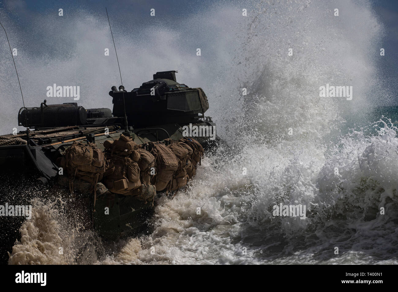 A U.S. Marine Corps amphibious assault vehicle assigned to Combat Assault Company, 3d Marine Regiment, crashes into the tides during an amphibious assault exercise at Marine Corps Training Area Bellows, Marine Corps Base Hawaii, Apr. 9, 2019. The unit conducted a simulated beach assault to improve their lethality and cooperation, as a mechanized unit and force in readiness. (U.S. Marine Corps photo by Sgt. Alex Kouns) Stock Photo