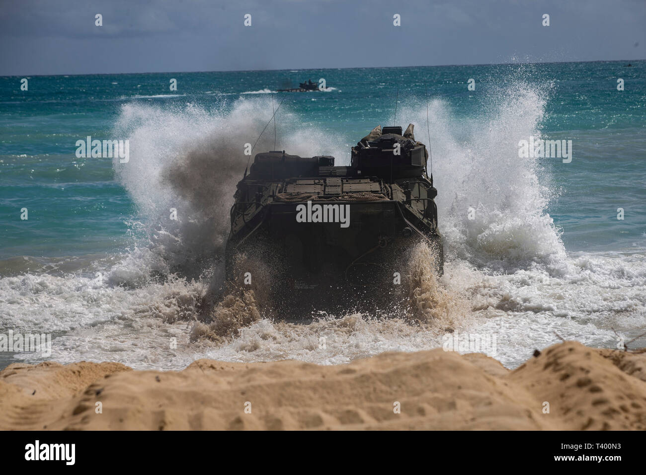 A U.S. Marine Corps amphibious assault vehicle assigned to Combat Assault Company, 3d Marine Regiment, crashes into the tides during an amphibious assault exercise at Marine Corps Training Area Bellows, Marine Corps Base Hawaii, Apr. 9, 2019. The unit conducted a simulated beach assault to improve their lethality and cooperation, as a mechanized unit and force in readiness. (U.S. Marine Corps photo by Sgt. Alex Kouns) Stock Photo