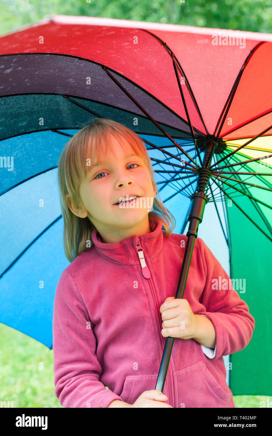 Portrait of jittle girl wearing fleece jacket standing hiding under