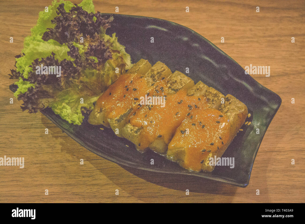 grilled japanese taro yam cake with black sesame seeds and lettuce