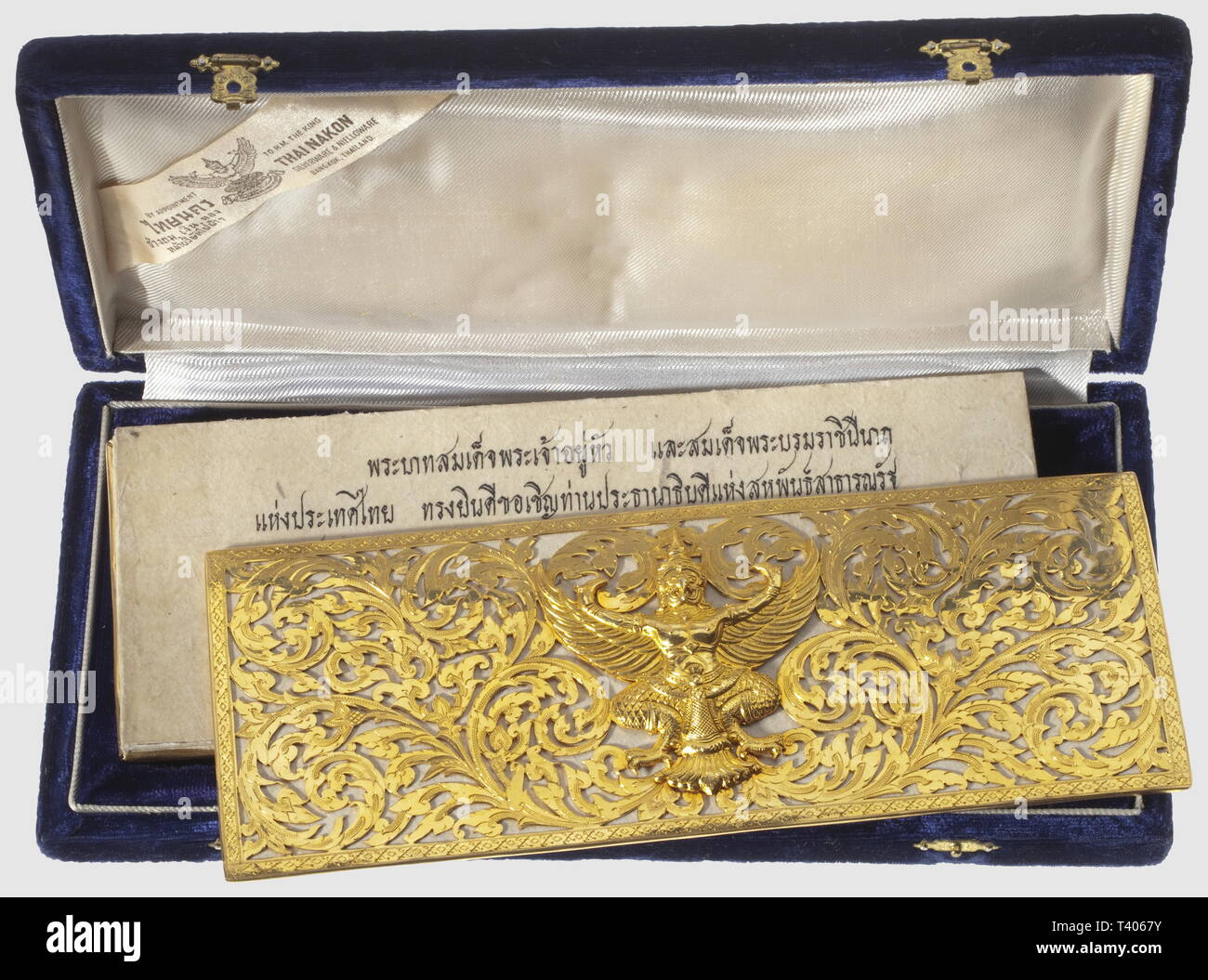 Invitation du Président Fédéral Allemand Heinrich Lübke, par sa Majesté le Roi et la Reine de Thailande, . Document inséré entre deux plaquettes d'or, richement ciselées et ornées de Phya Khrut, 220 X 85 mm, dans son coffret de velours bleu nuit, de la maison "Thai Nakon, Bangkok", 255 x 125 mm. "Sa Majesté le Roi et Sa Majesté la Reine de Thailande ont le plaisir d'inviter le Président de la République Fédérale d'Allemagne et "Frau Subede" pour le gala officiel (dŒner) que le Gouvernement de la Thailande donnera en l'honneur de Votre Excellence , Additional-Rights-Clearance-Info-Not-Available Stock Photo