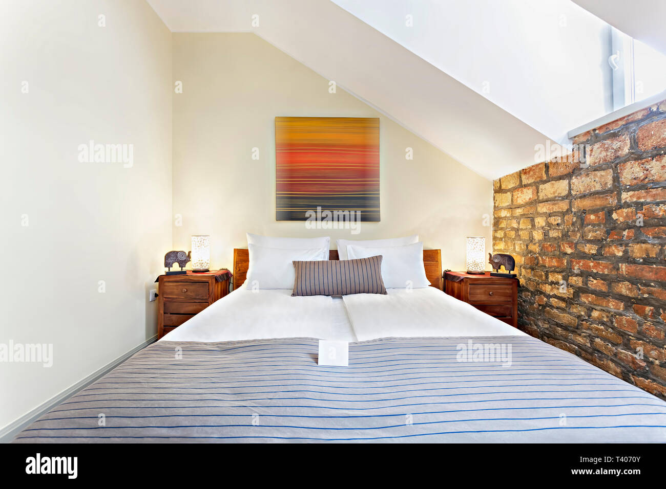 Bedroom interior in luxury loft, attic, apartment with roof windows - Hotel room - vacation concept background Stock Photo