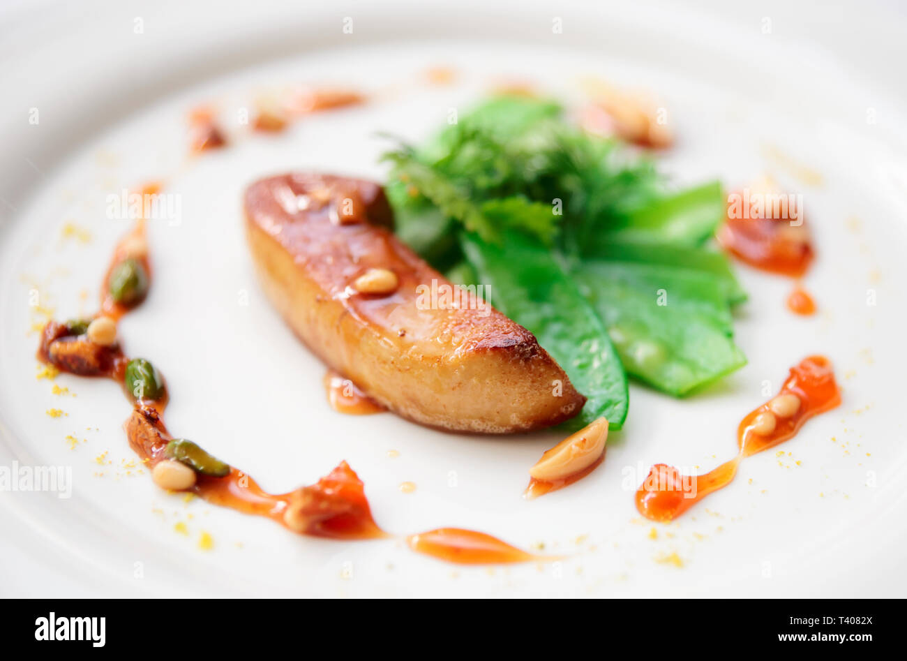 Fried foie gras with caramelized nuts and vegetables, shallow focus depth Stock Photo