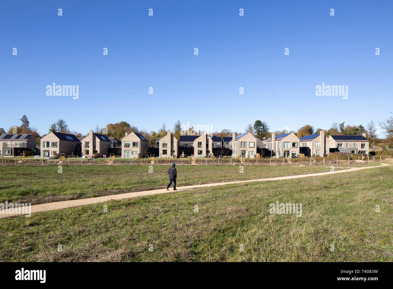 Wide view of housing across meadow. Lovedon Lane, Kings Worthy, United Kingdom. Architect: John Pardey Architects & HAB, 2018. Stock Photo