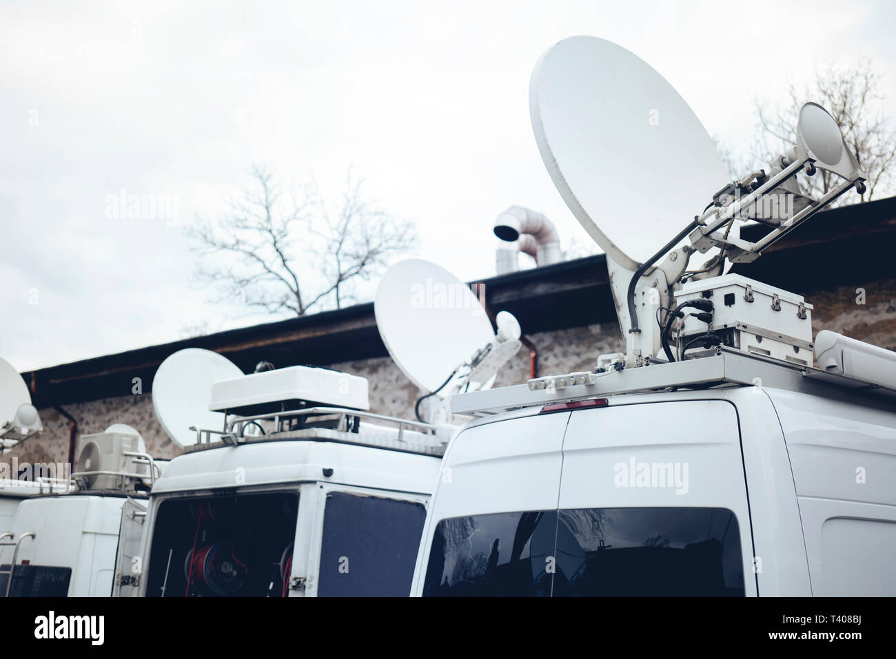 TV Media Television Trucks with multiple Satellite parabolic antennas and fiber optic cables preparing to report live a political sport or other news  Stock Photo