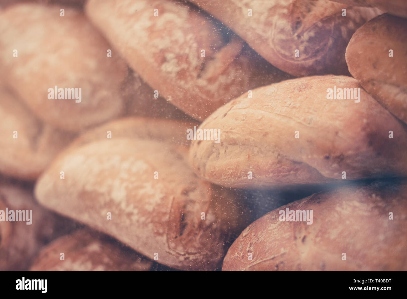 white bread rolls or buns at bakery showcase behind the glass - Stock Photo