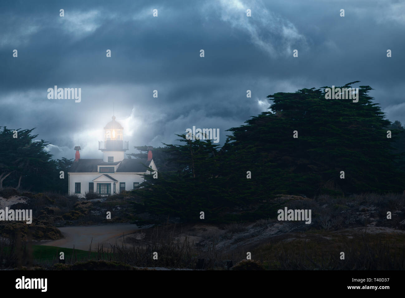Point Pinos Lighthouse in Pacific Grove California on a stormy night with dramatic clouds. Monterey Peninsula trave destination. Stock Photo
