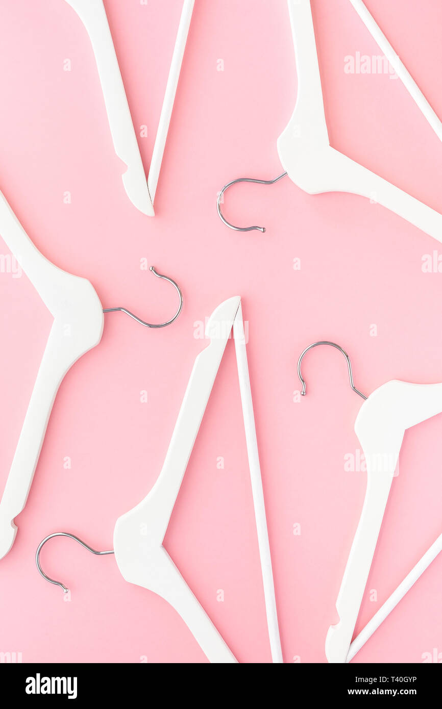 Creative top view flat lay white wooden hangers pastel millennial pink ...