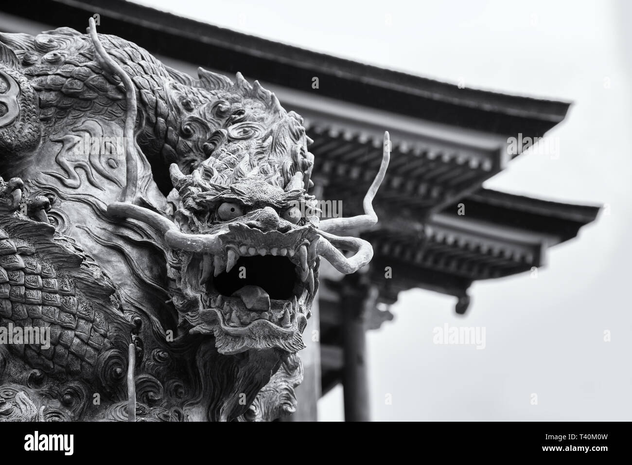 Black and white closeup of an ancient dragon statue outside of the Kiyomizu-dera temple on Mount Otowa. Image taken from a public street. Stock Photo