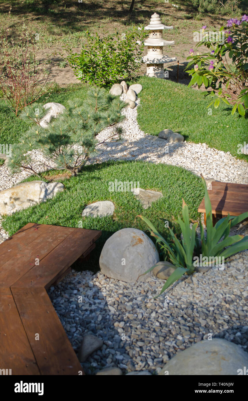 Small oriental garden for relaxing. Japanese stilb with pebble paths. Stock Photo