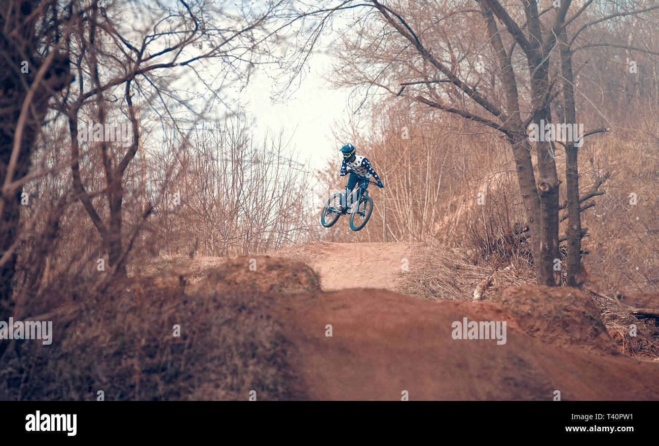 Moscow, Russia - Apr 12, 2019: Jump and fly on a mountain bike. Rider in action at mountain bike sport. Biker riding in nature. Cool athlete cyclist o Stock Photo