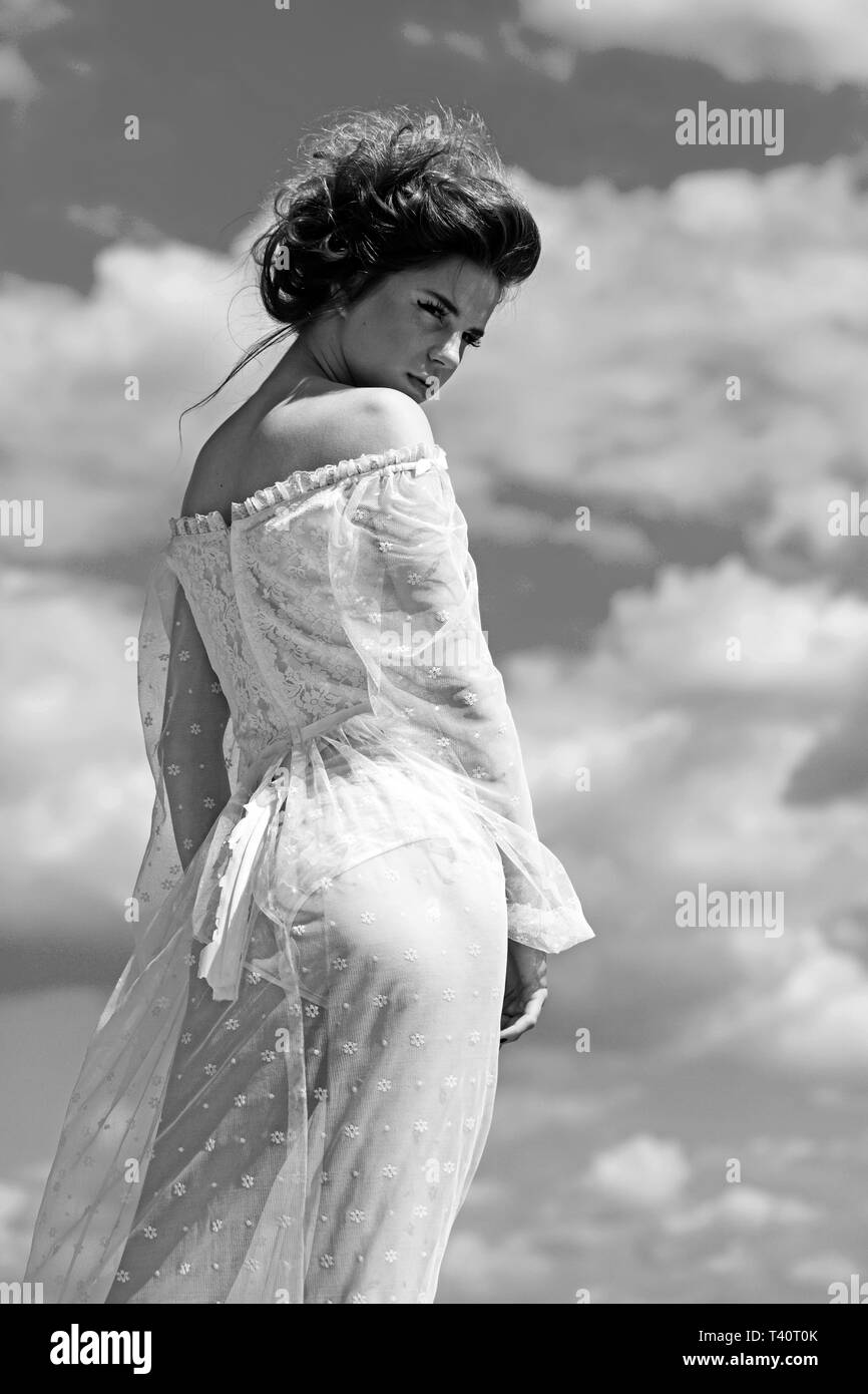 woman in a white dress on the blue sky background. Stock Photo