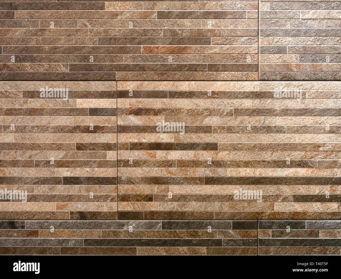 abstract pattern wall made of brown granite stones thin blocks bricks Stock Photo