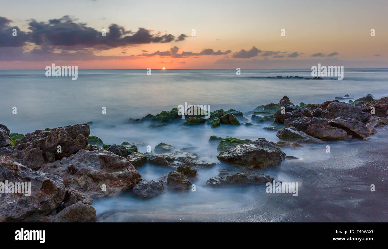 Sunset over the rocky shore of the Gulf of Mexico at Caspersen Beach in Venice Florida Stock Photo