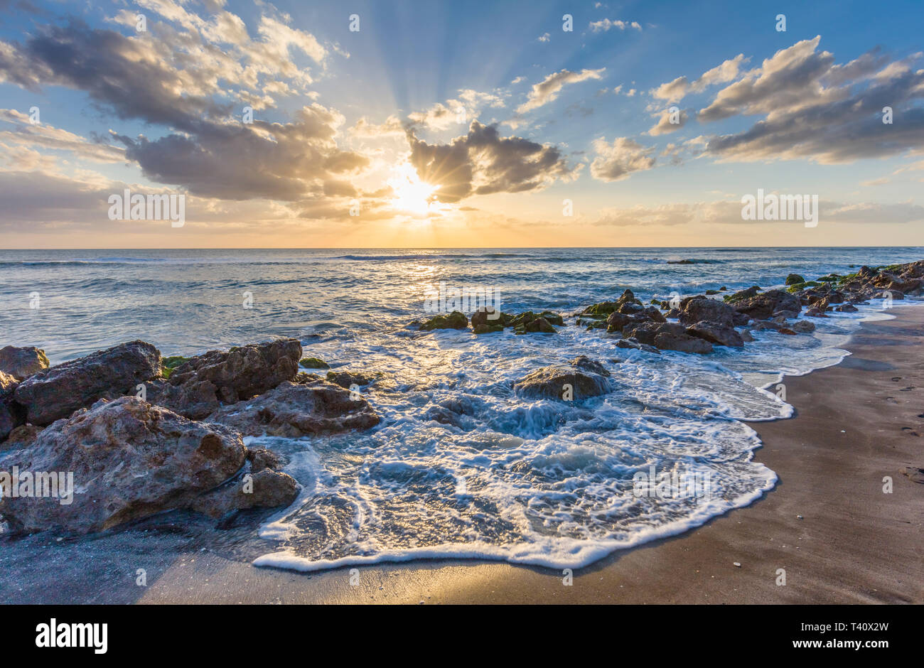 Sunset over the rocky shore of the Gulf of Mexico at Caspersen Beach in Venice Florida Stock Photo