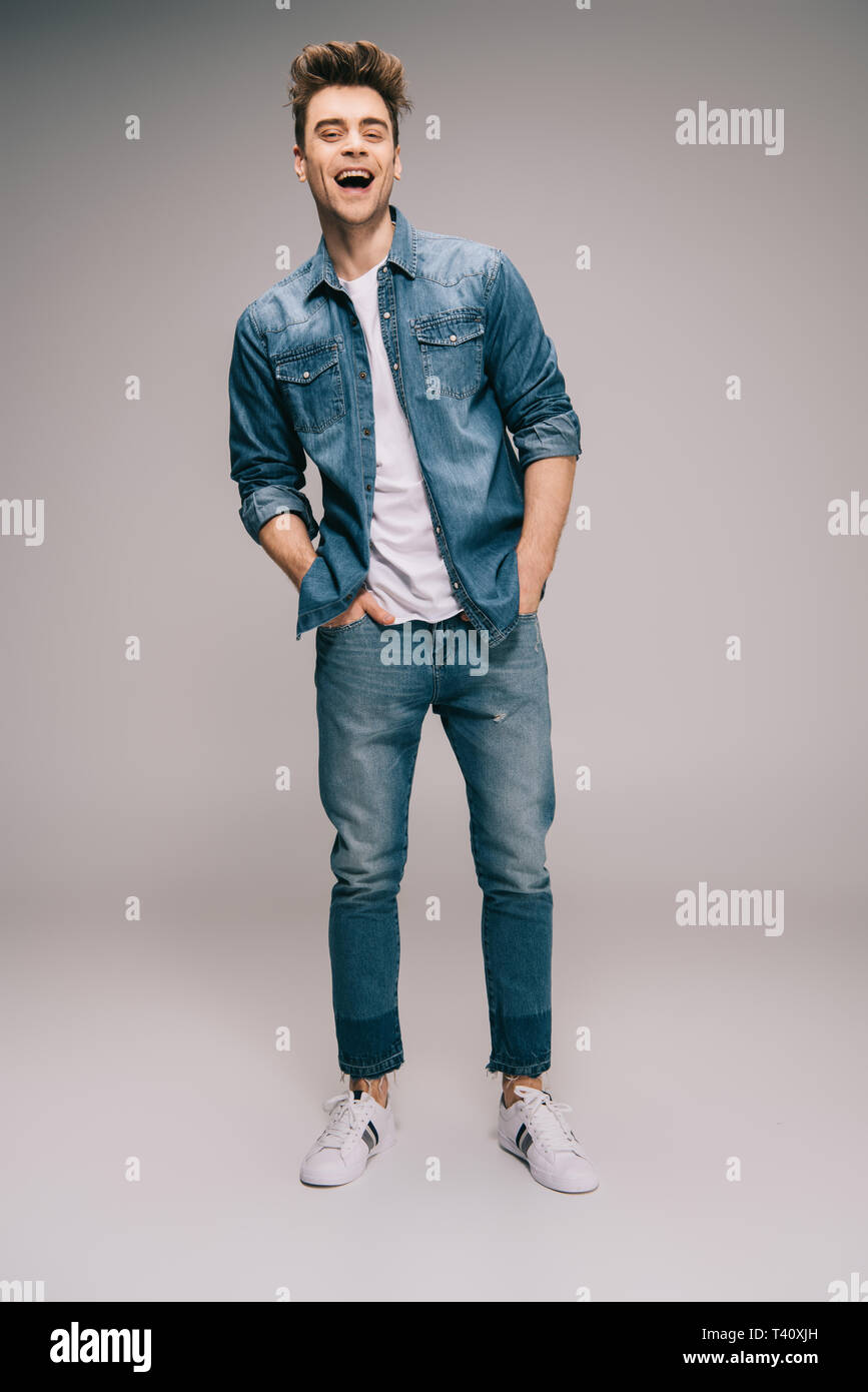 smiling and good-looking man in jeans, skirt and t-shirt with hands in  pockets looking at camera Stock Photo - Alamy