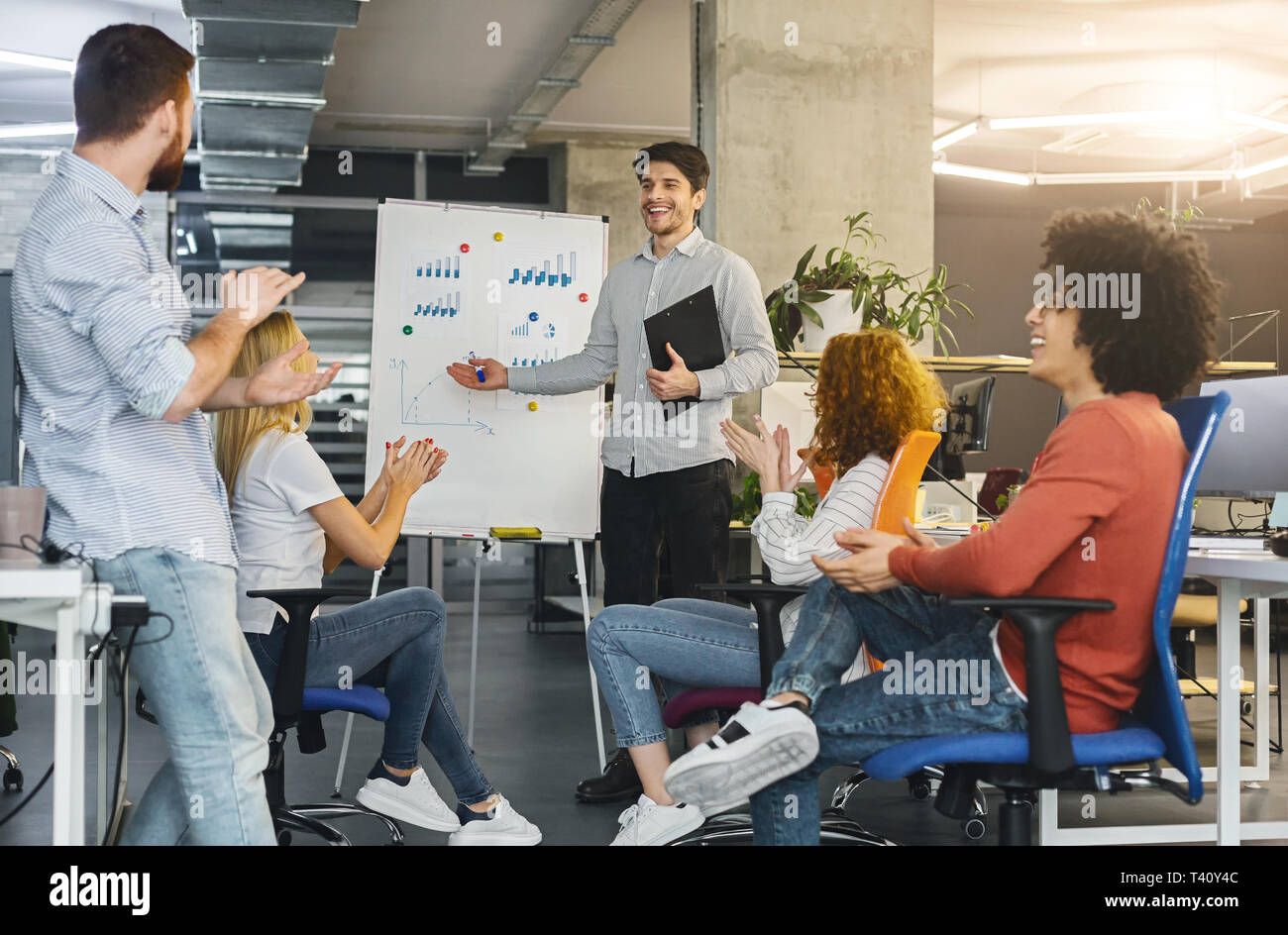 Young millennial team analyzing information on graphs and charts Stock Photo