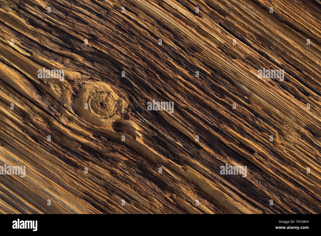 a deeply weathered textured old wooden board with with a single knot breaking the pattern Stock Photo