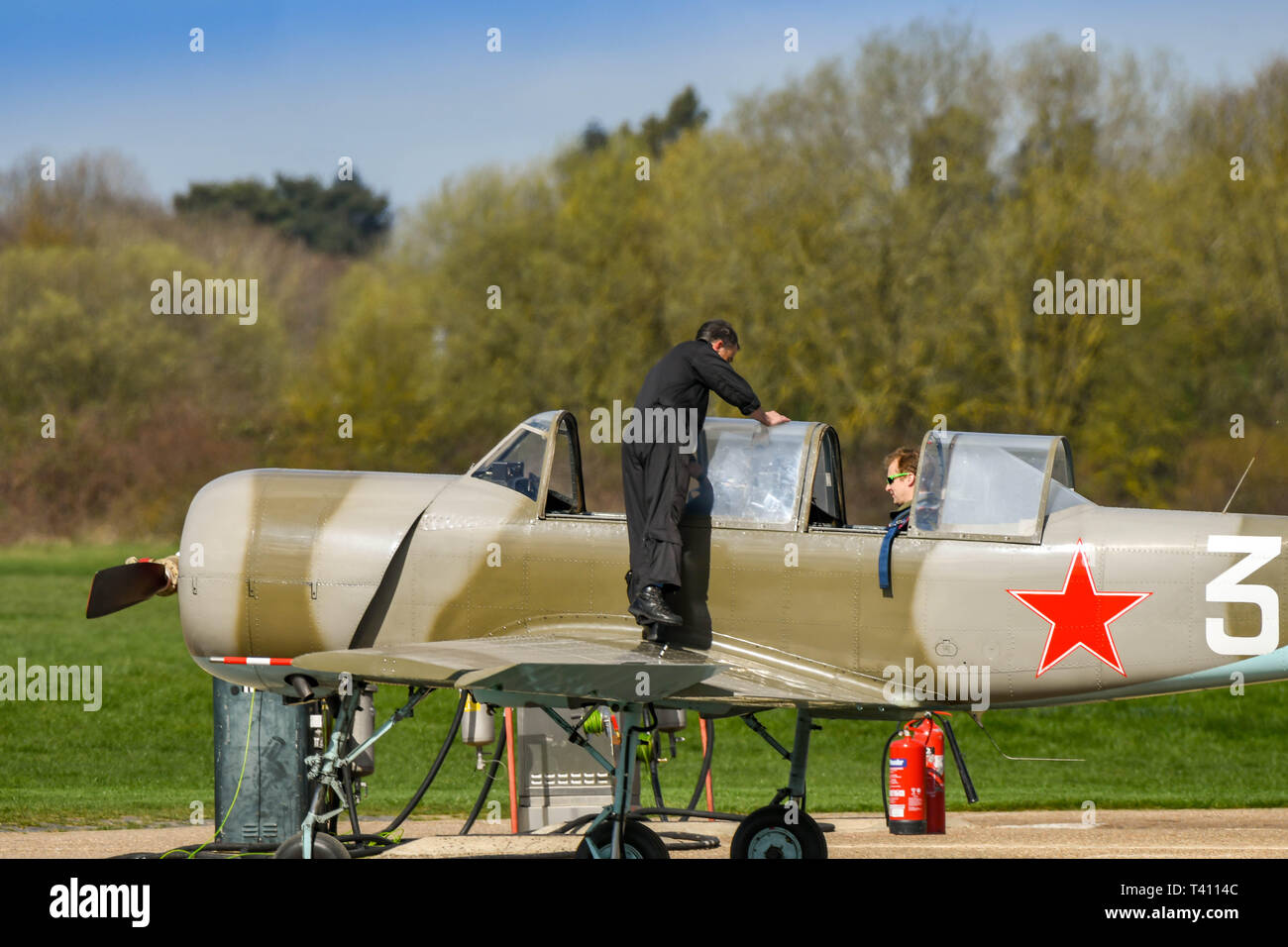 WHITE WALTHAM, ENGLAND - MARCH 2019: Person standing on the wing of a Yakolev Yak light aircraft at White Waltham airfield. Stock Photo