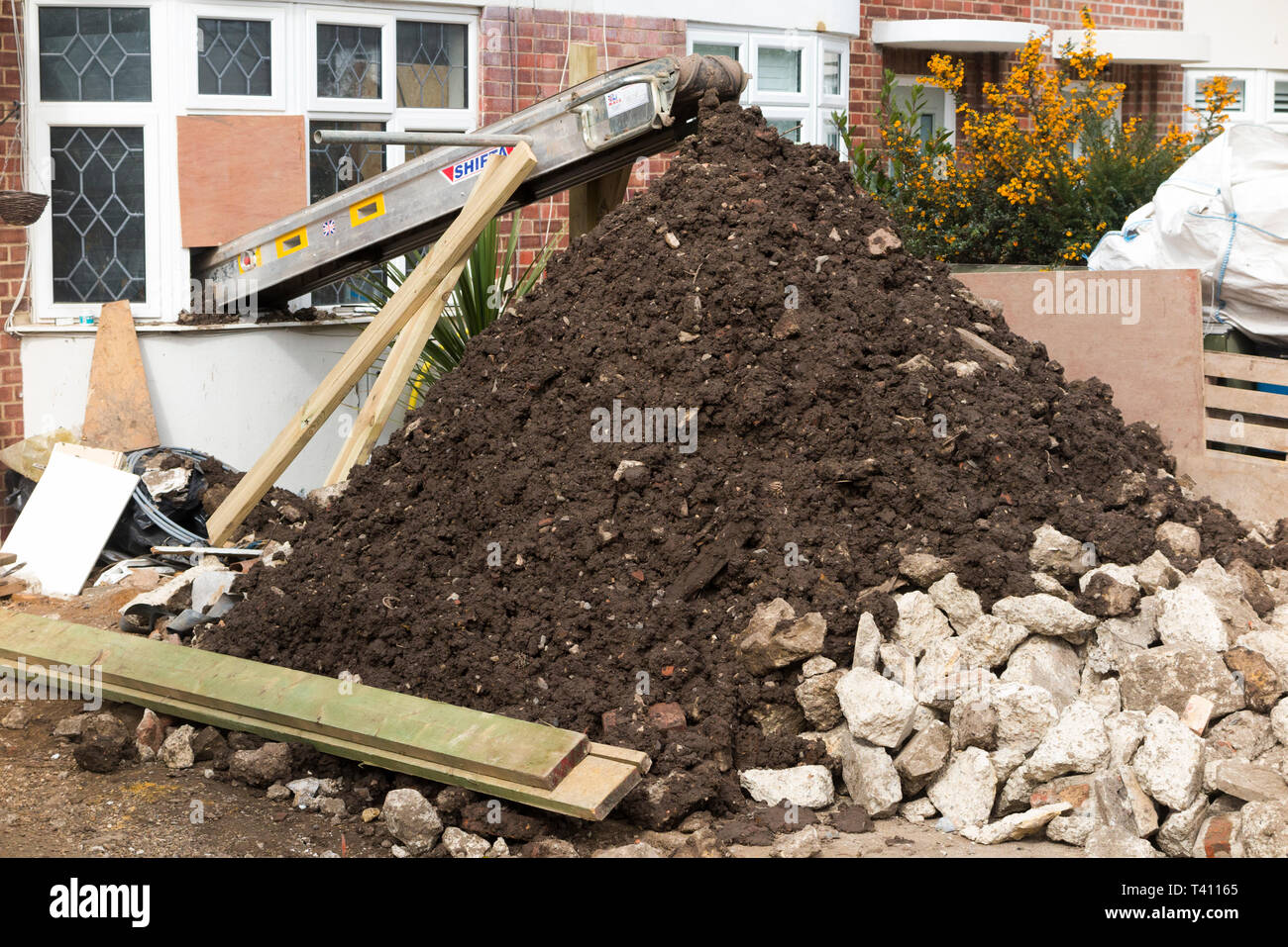 Machine / conveyor belt removing soil debris and spoil waste from house