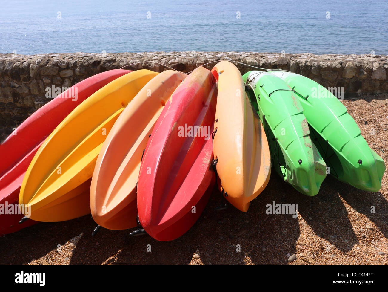 Colorful kayaks on shore at the beach Stock Photo - Alamy