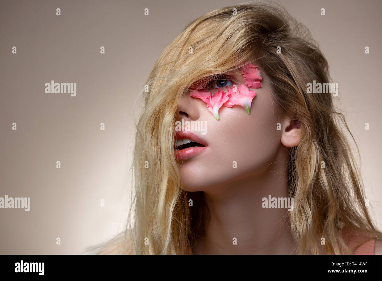 Tender Young Model Having Blonde Wavy Hair On Her Face Stock Photo