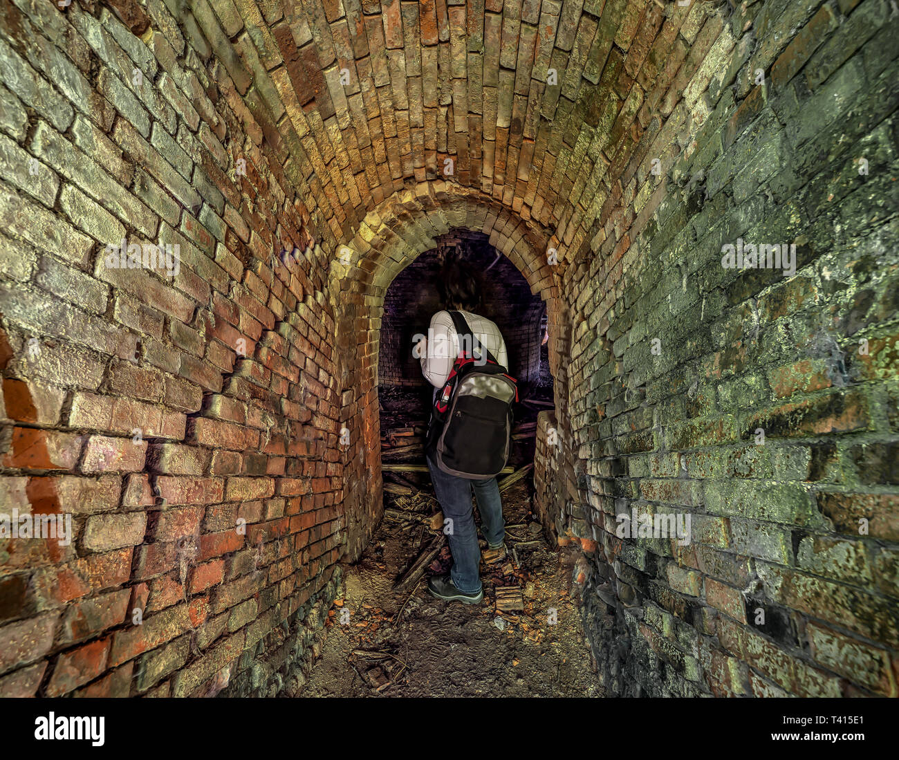 Woman at the entrance of an underground catacombs Stock Photo