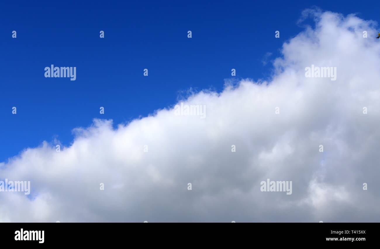 Beautiful fluffy white cumulus and cirrus clouds on a deep blue sky ...