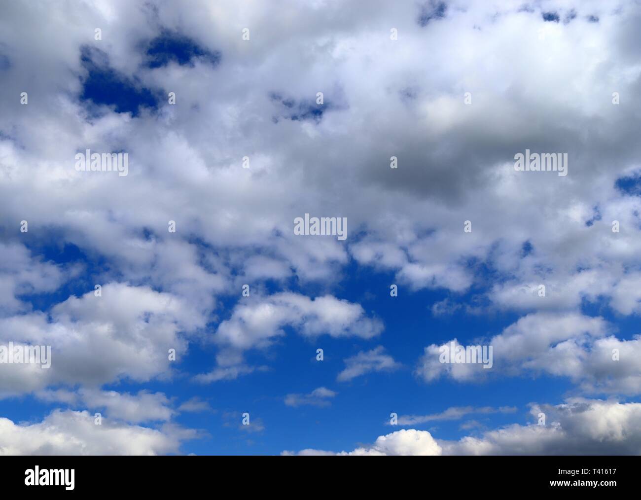 Beautiful fluffy white cumulus and cirrus clouds on a deep blue sky ...