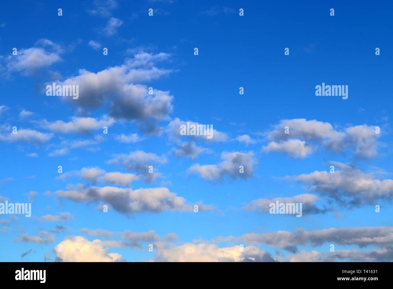 Beautiful fluffy white cumulus and cirrus clouds on a deep blue sky ...