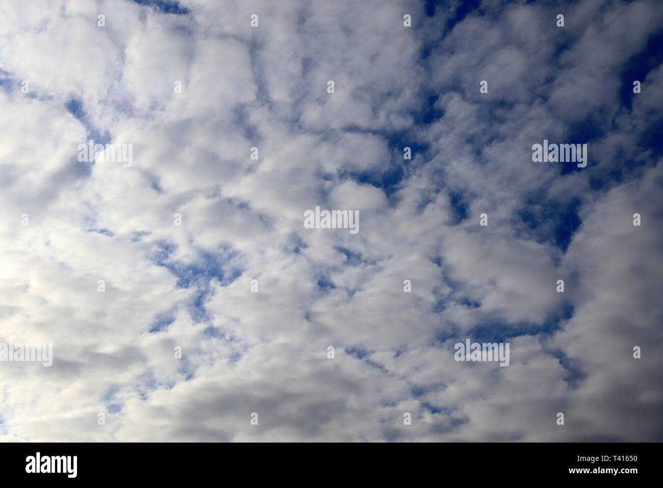 Beautiful fluffy white cumulus and cirrus clouds on a deep blue sky ...