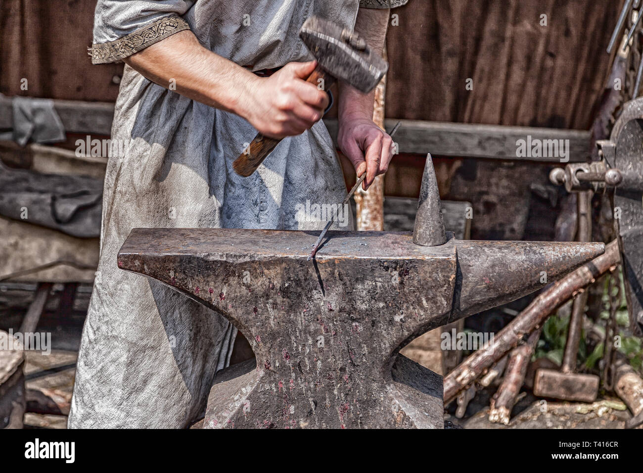 Medieval blacksmith at work with hammer and anvil. Stock Photo