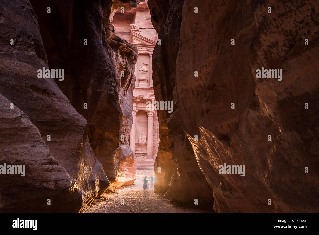Two people standing in gorge by the Treasury, Petra, Jordan Stock Photo