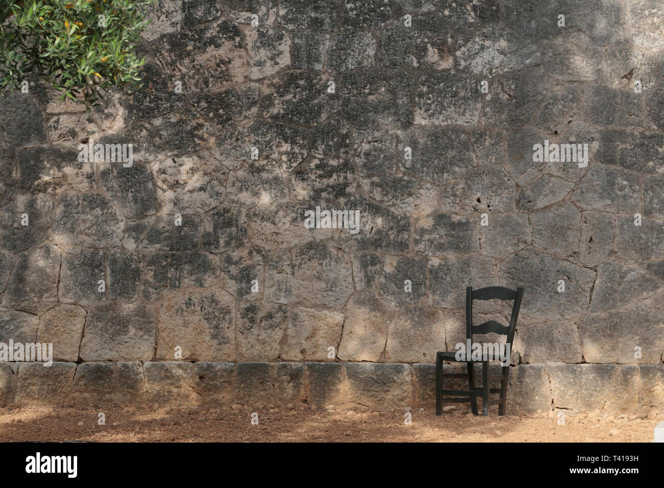 Chair next to a memorial wall for Spanish civil war, Majorca, Spain Stock Photo