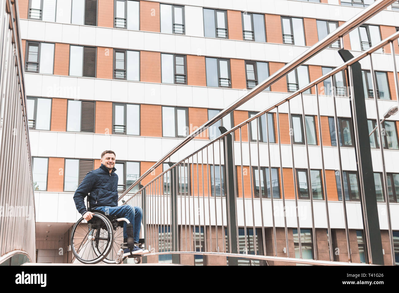 Man in a wheelchair use a wheelchair ramp Stock Photo - Alamy