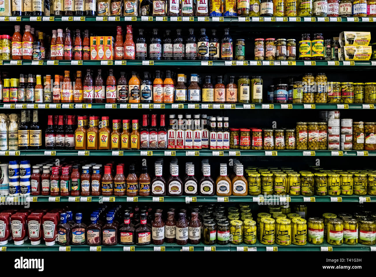 Condiment brands displayed on the shelves of a grocery store. Stock Photo