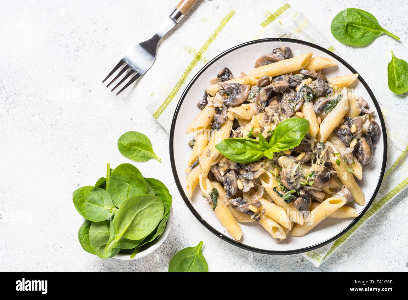 Pasta with mushrooms and spinach on white Stock Photo - Alamy