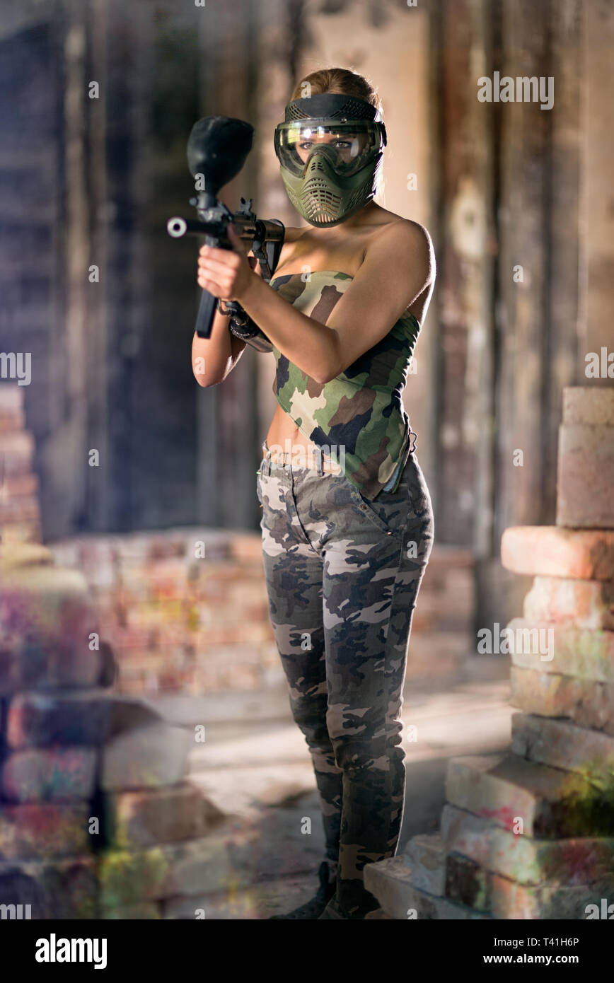 Attractive woman paintball player with gun and mask Stock Photo