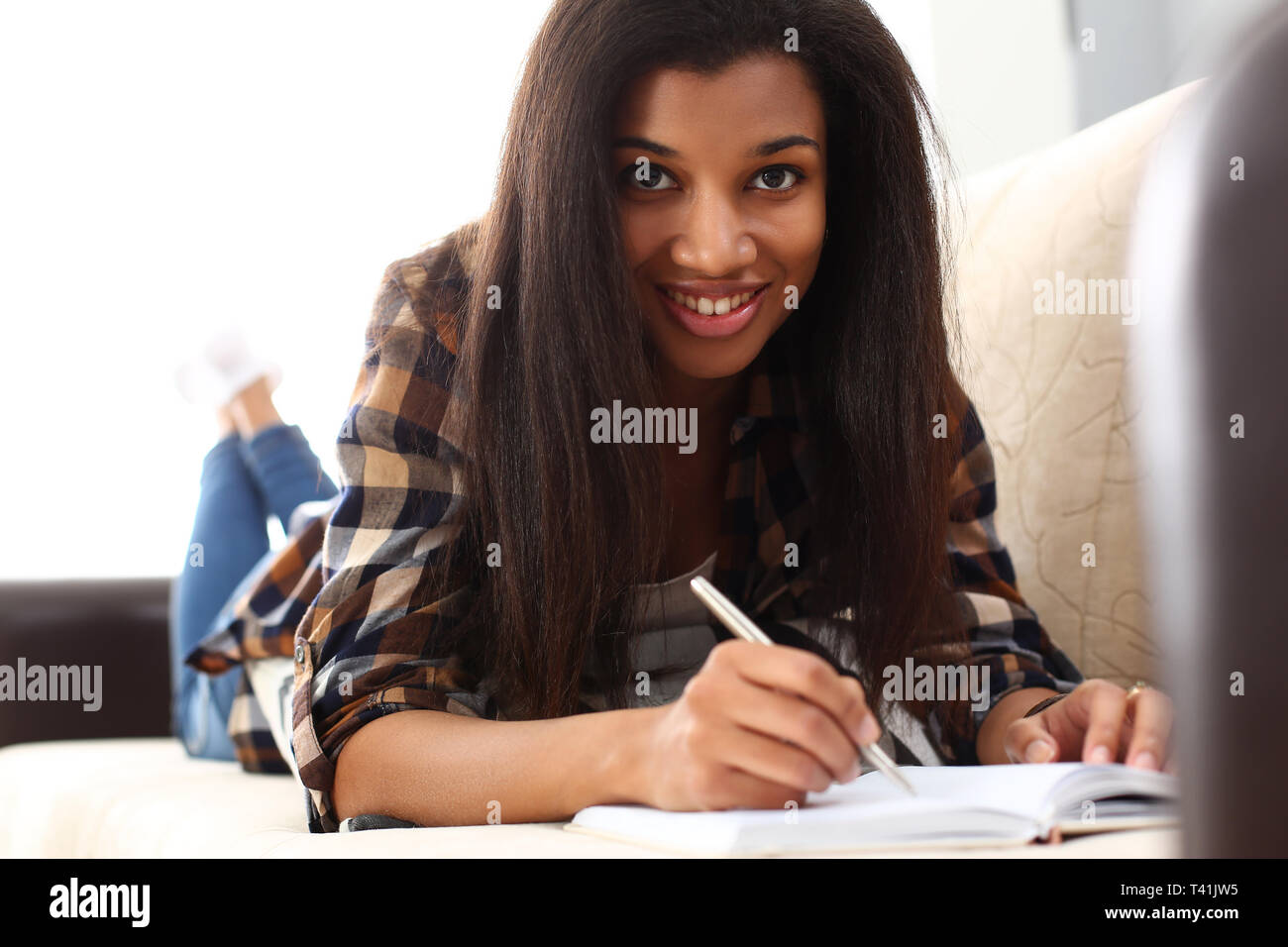 Smiling black woman write story in notebook Stock Photo - Alamy