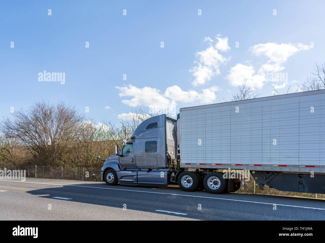 Gray long haul professional freight big rig semi truck transporting