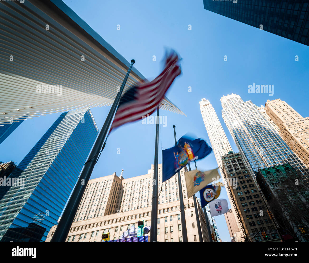 An American flag along with state, city and governmental agency flags are whipped around by the wind outside of the World Trade Center Transportation Hub in Lower Manhattan in New York on Wednesday, April 3, 2019. (Â© Richard B. Levine) Stock Photo