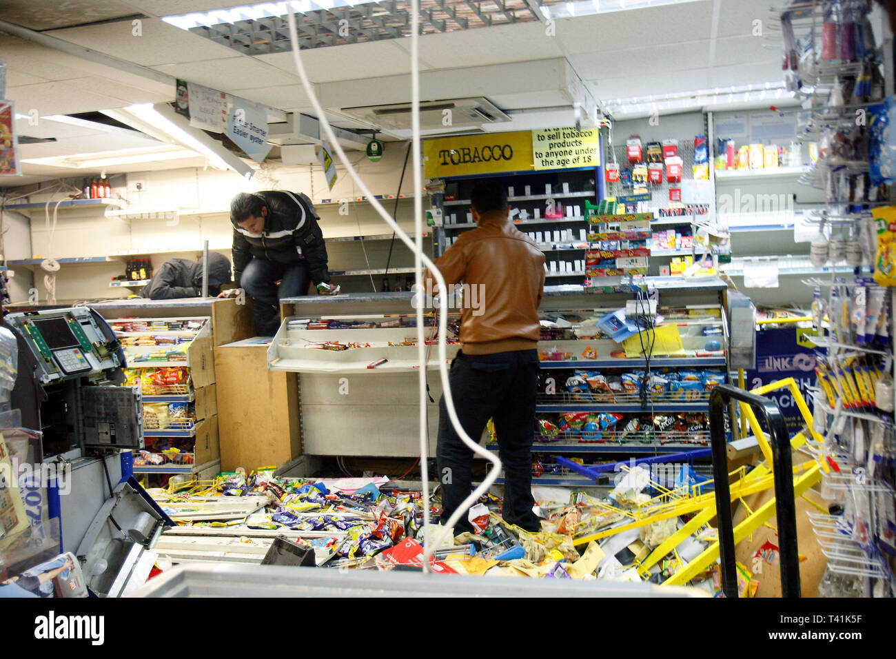 Goods are taken from a shop in Hackney during rioting. Pembury Estate, London. 8 August 2011. Stock Photo