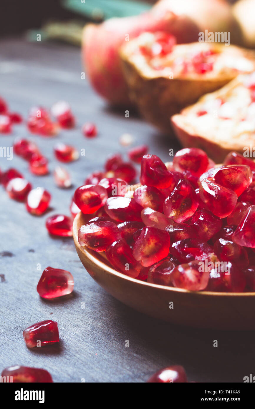 wooden spoon with a red fruit pomegranate seeds Stock Photo