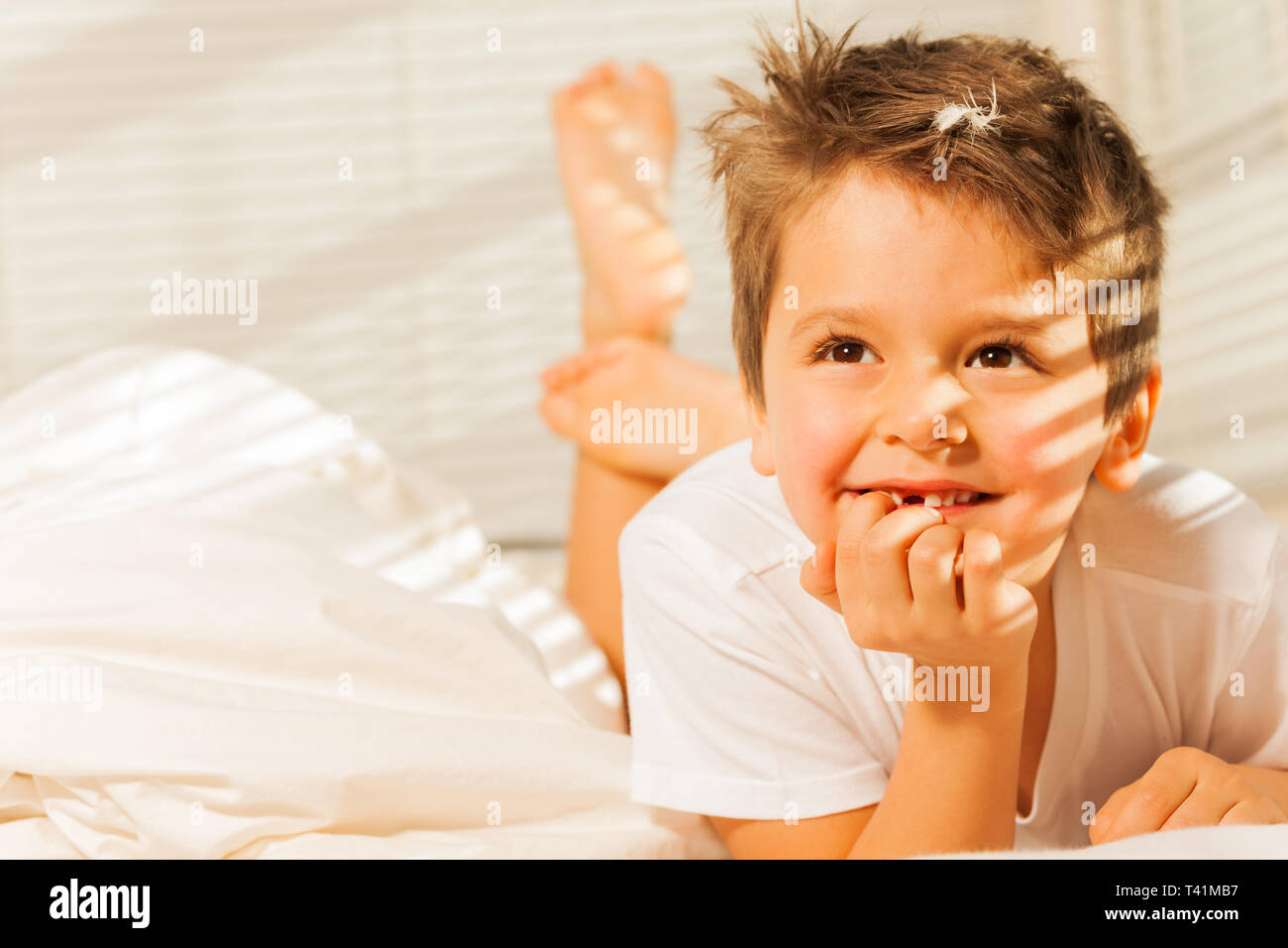 Happy little boy laying and dreaming in his bed Stock Photo Alamy